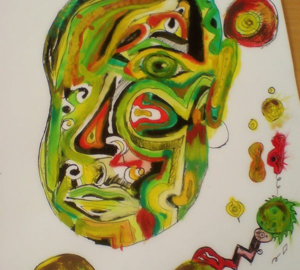 Zelená hlava namalovaná akrylovkami na velkém výkresu, na hlavě je mnoho barevných žlutých a červených detailů, kolem hlavy je spousta barevných kruhů.