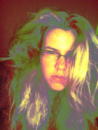 Fotografie Zrzavé holky s ještě světlou barvou vlasů, polovina obrovských hustých vlasů jí zakrývá dlouhý obličej.